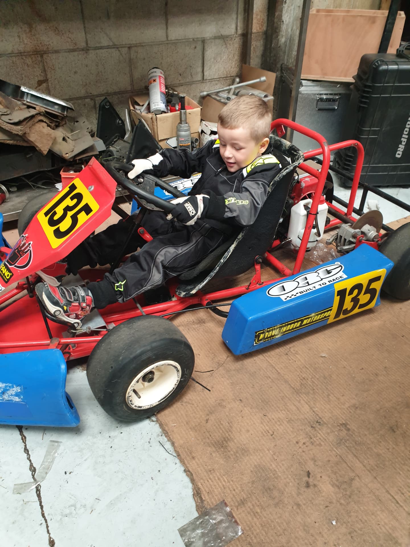 A young Niko Hewson sitting in his first go-kart in the family garage