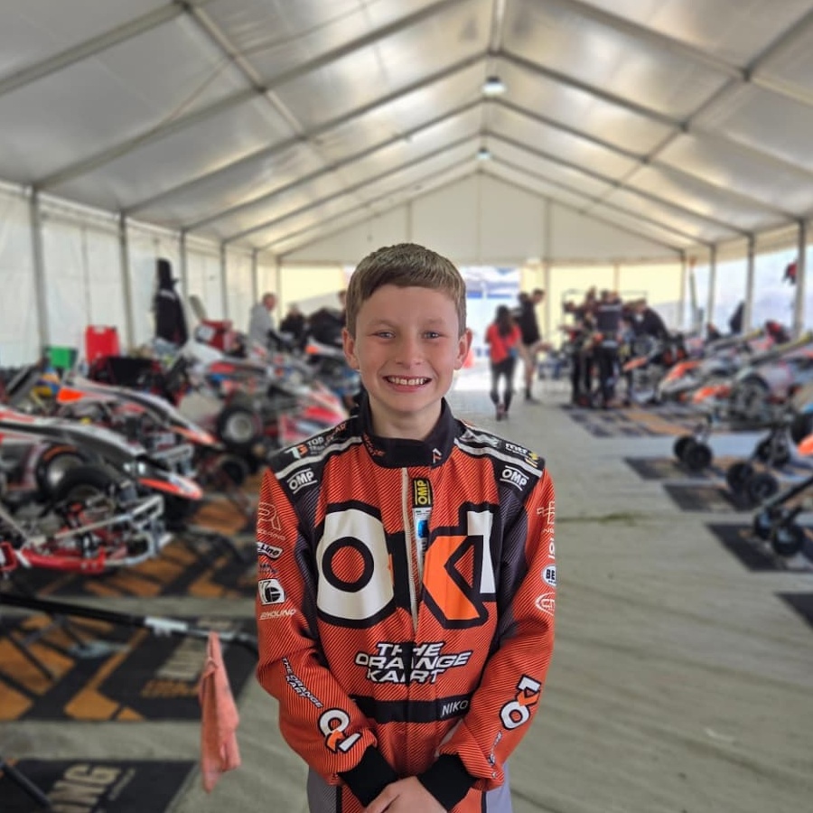 Niko Hewson smiling in his orange racing suit